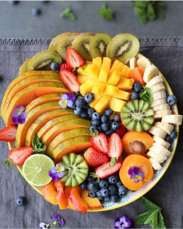 Mesa con frutas frescas, vegetales y alimentos saludables preparados de forma sencilla